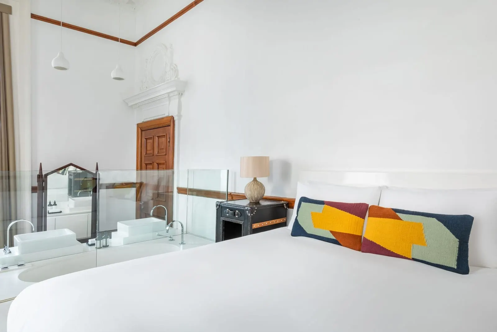 Signature Junior Suite at Town Hall Hotel: the bed before a glass partition, with a carved plaster doorcase beyond