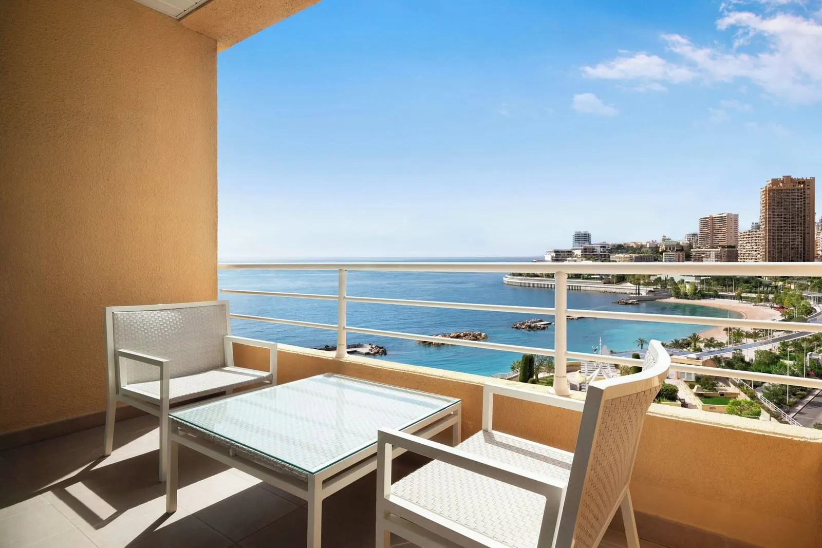 Premium room with partial sea view at Le Méridien Beach Plaza: the balcony table and chairs, the bay and towers beyond