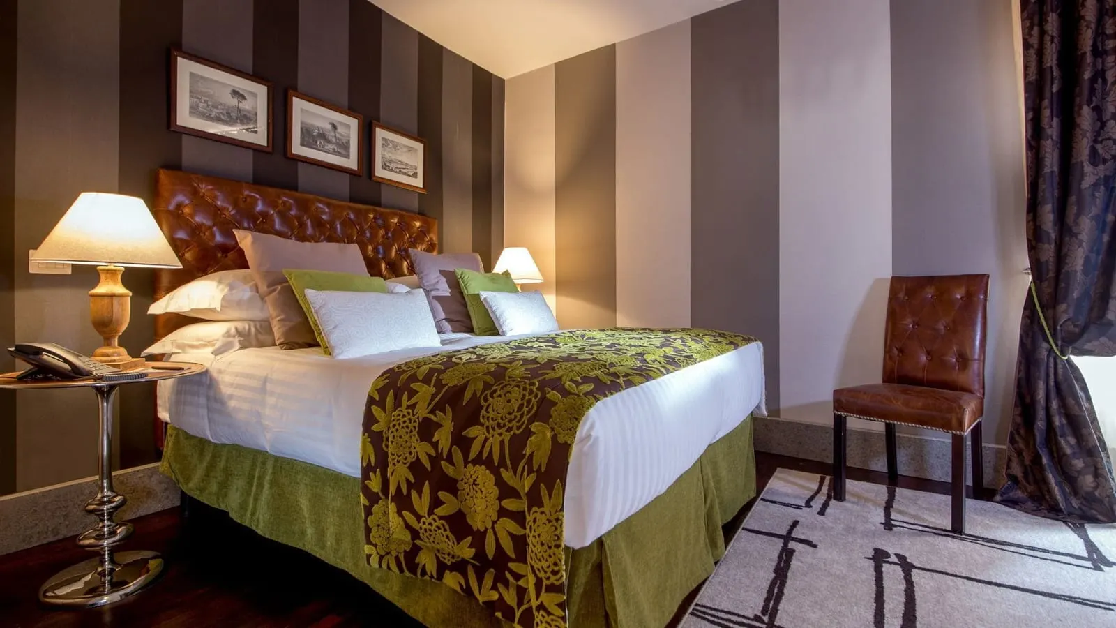 2 Bedroom 2 Floor Apartment at The Inn at the Roman Forum: a bed with a leather headboard and a green throw, striped walls