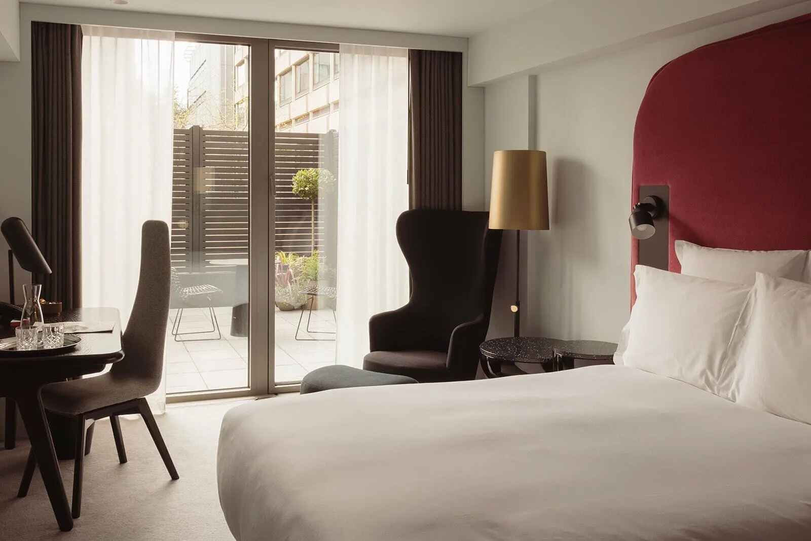 Superior Patio Room at Sea Containers London: the bed, a wing chair and glass doors onto the patio