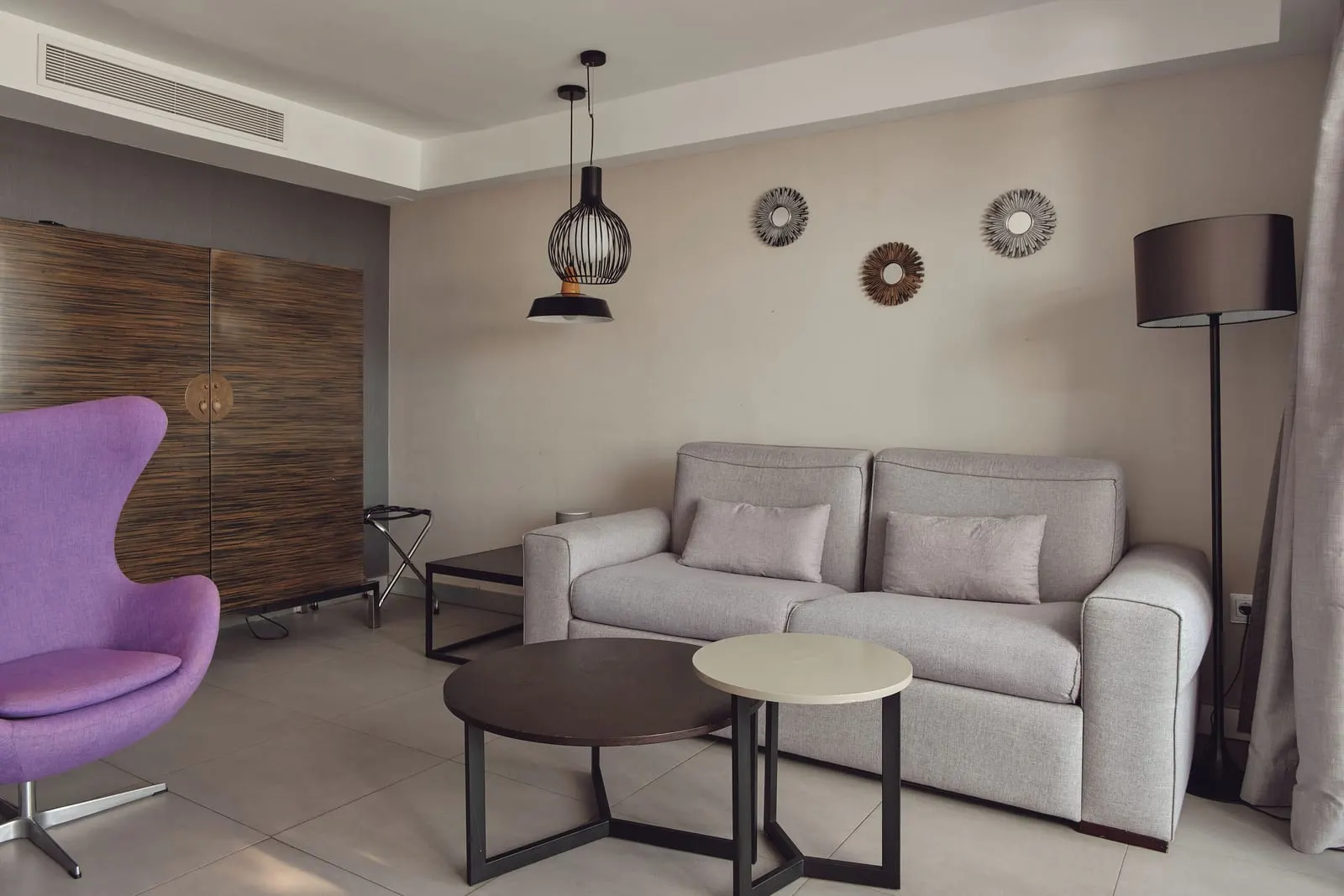 Suite Excellence Atlantic at La Isla y el Mar Hotel Boutique: a sitting area with a grey sofa, low tables and a purple armchair