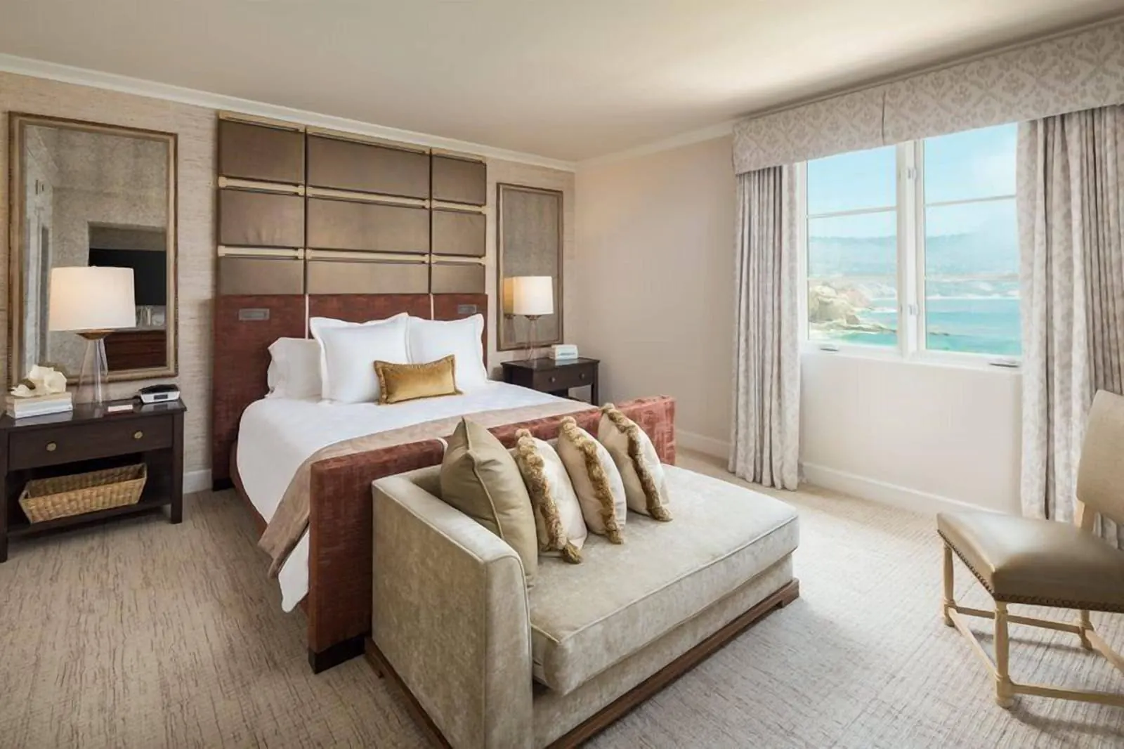 Shearwater Suite at Terranea Resort: a bed with a padded headboard and a chaise at its foot, beside a window with the sea beyond