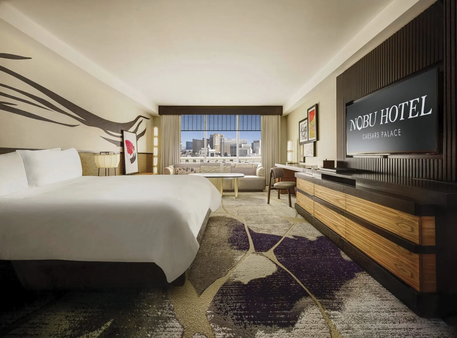 Nobu Deluxe Room im Caesars Palace: ein Kingsize-Bett, eine lange Holzkommode unter einer TV-Wand und ein Sofa am Fenster
