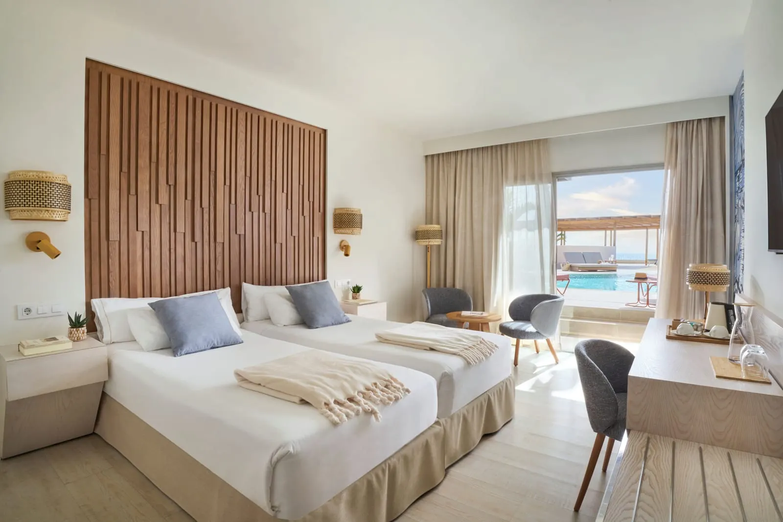 Side Sea-View Sharing Pool Double im Iberostar Selection Fuerteventura Palace: zwei Einzelbetten unter einem Kopfteil aus Holzlatten, mit einer offenen Glastür zu einer Terrasse und einem Pool