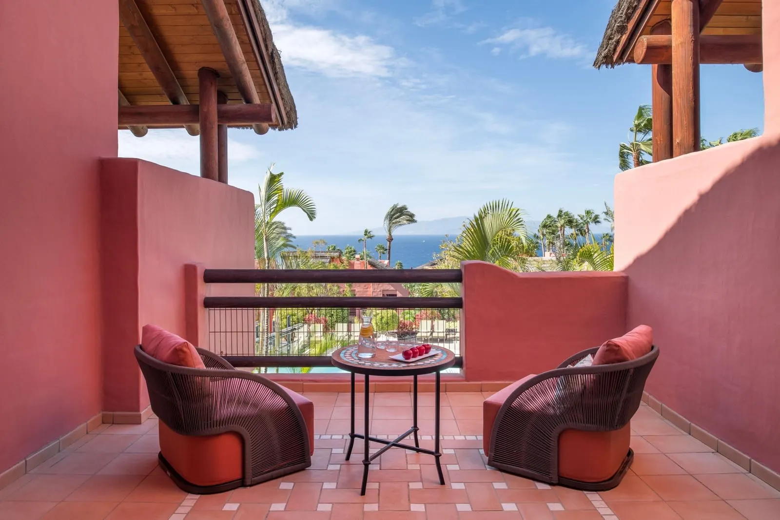 Retreat Deluxe Room Ocean View terrace at the Ritz-Carlton Abama: two armchairs and a table, with palms and the sea beyond