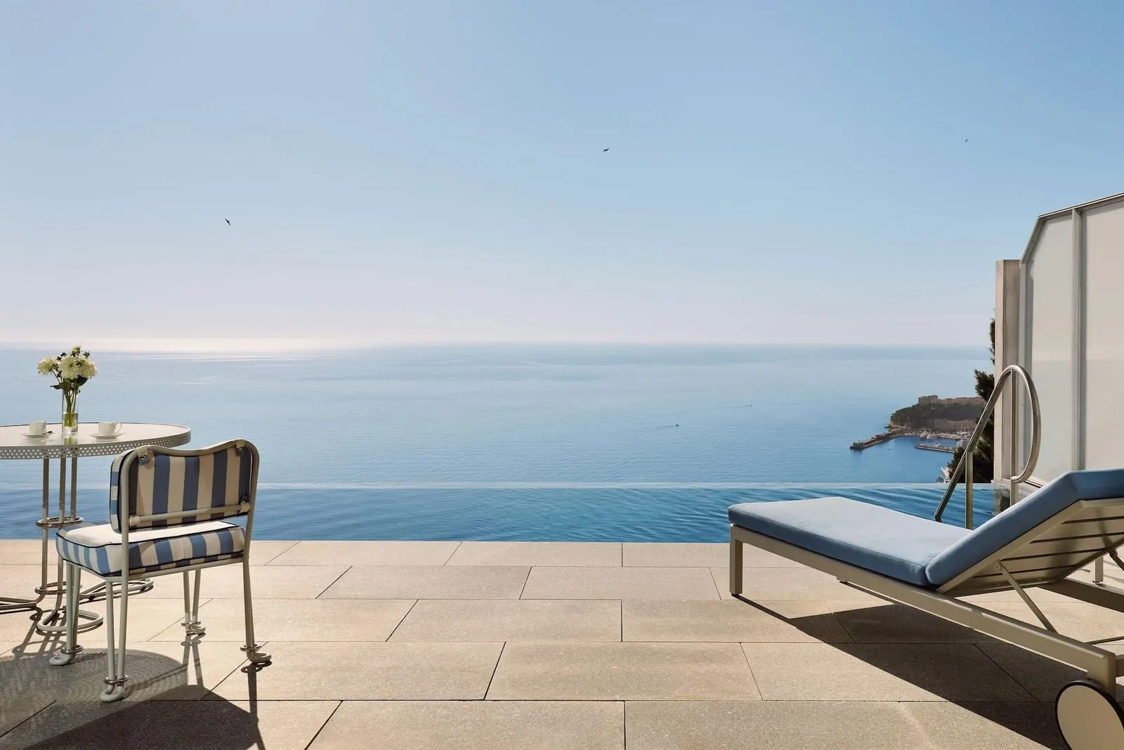 Infinity Blue Suite at The Maybourne Riviera: the terrace and its infinity pool, with a lounger and a table facing the sea