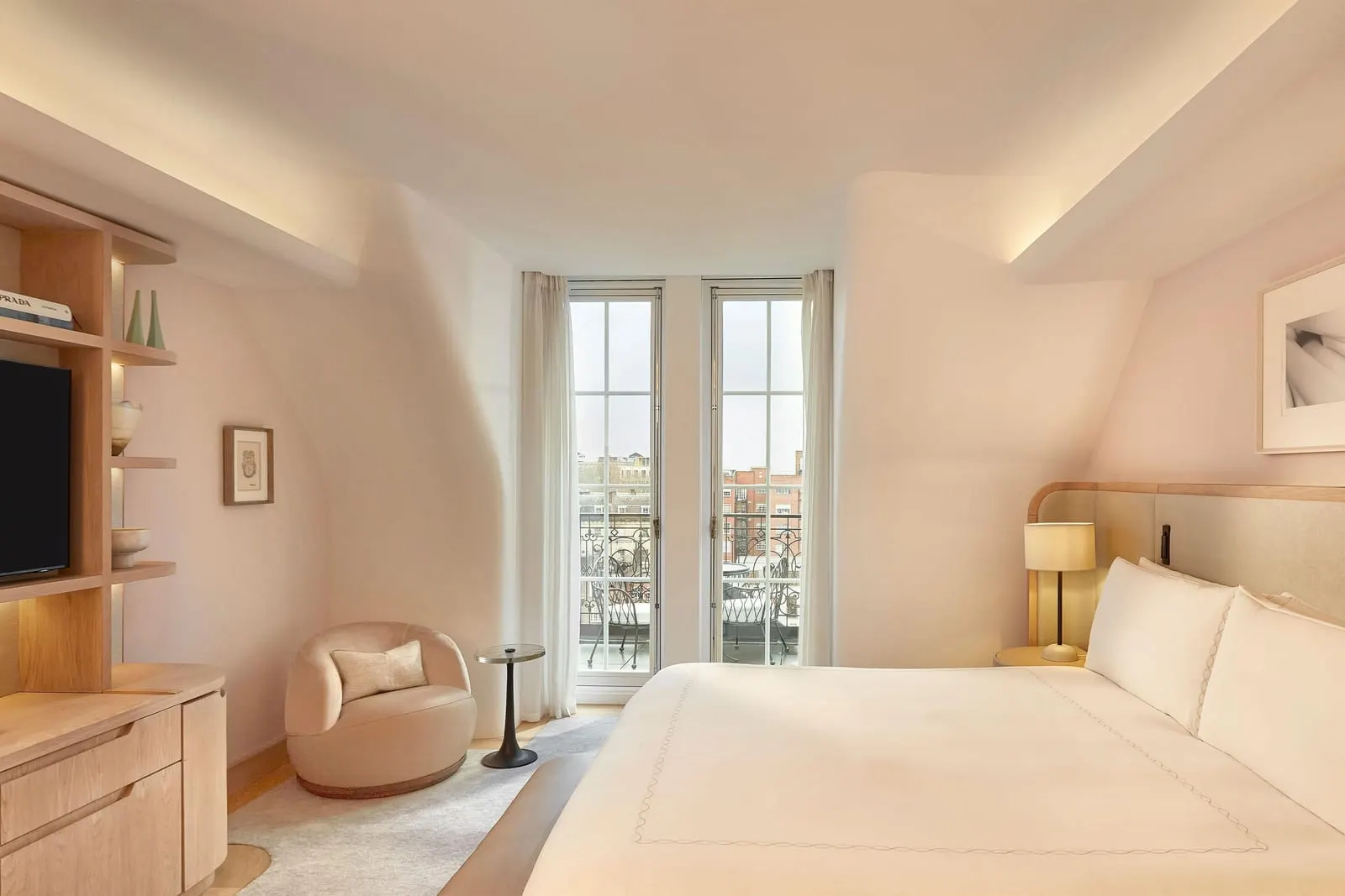 Mayfair Balcony Room at Claridge's: the bed, a round armchair, shelves with a television and French doors to the balcony