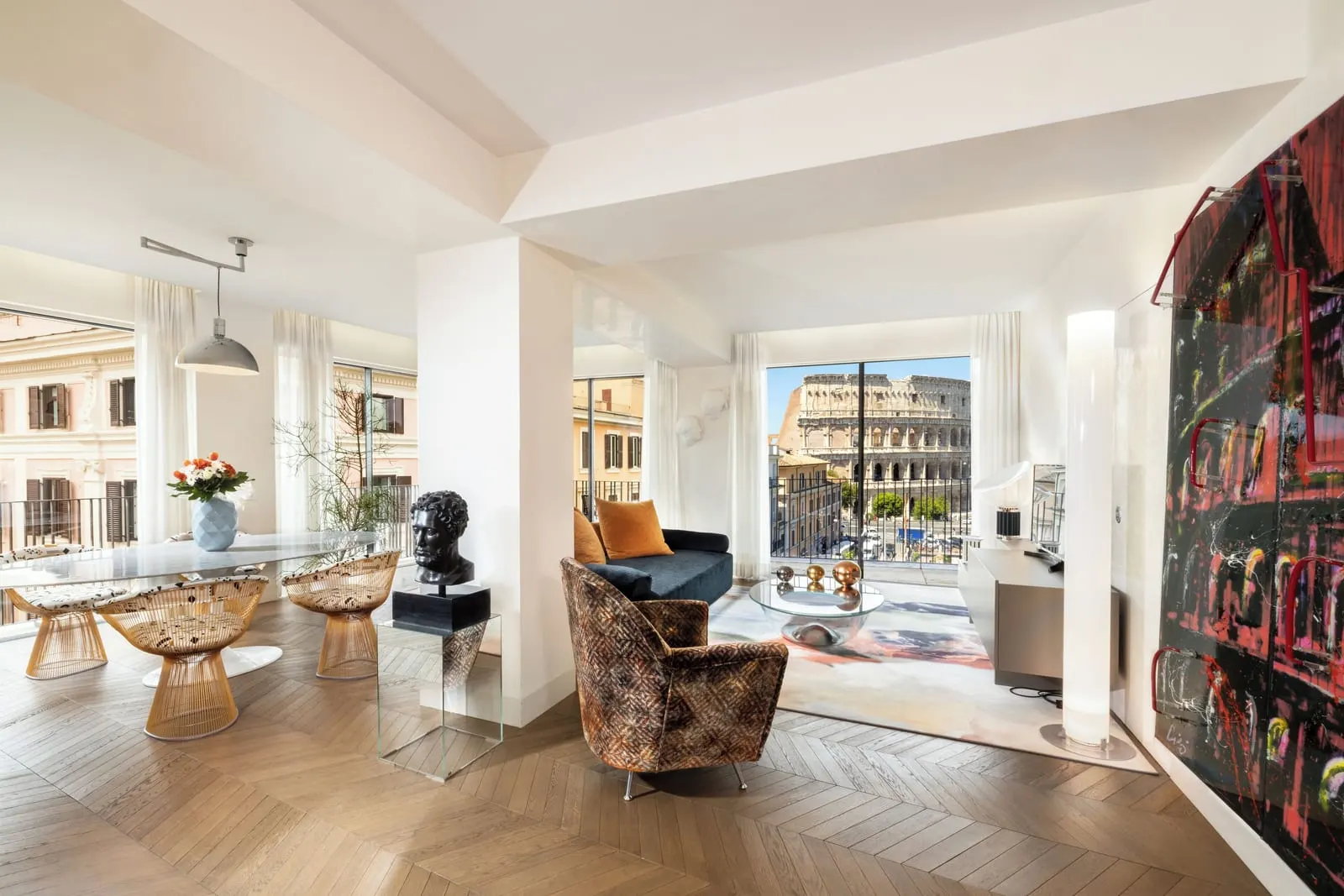 Grand View Penthouse at Palazzo Manfredi: the open living and dining room, with the Colosseum through the far window