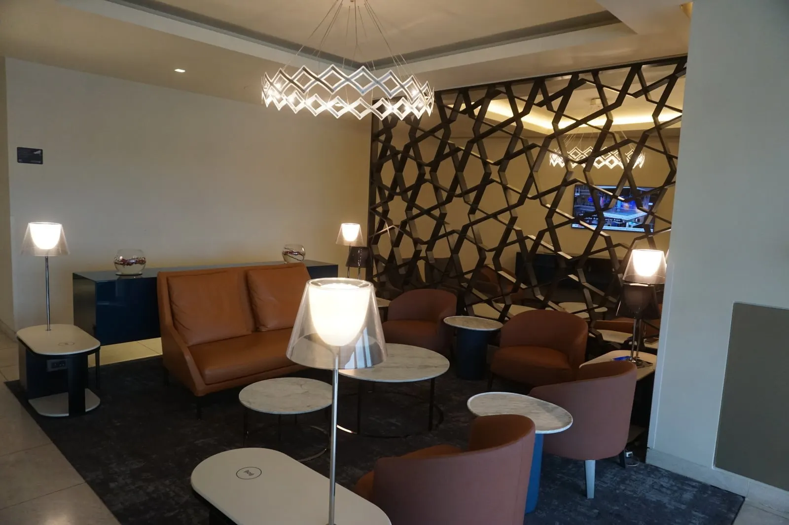 Leather armchairs and lattice screen in the Qatar Airways lounge, Heathrow Terminal 4