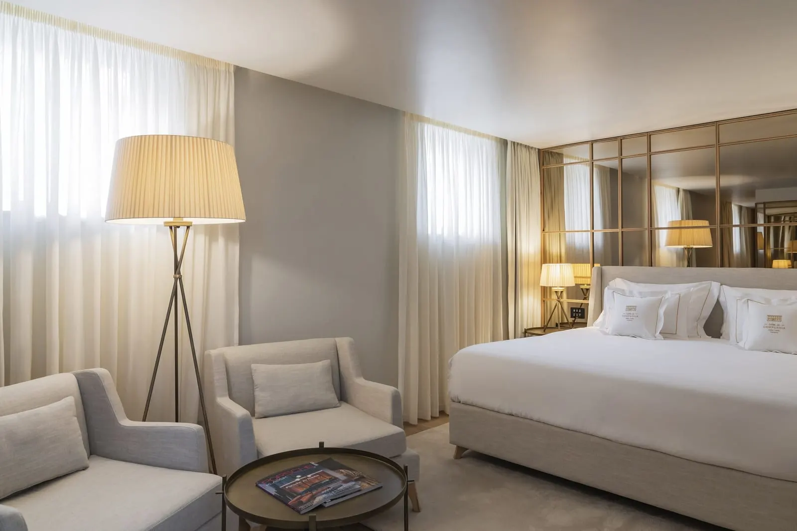 King Suite Sé Cathedral View Balcony at Casa da Companhia: two armchairs and a floor lamp by the windows, the bed beyond