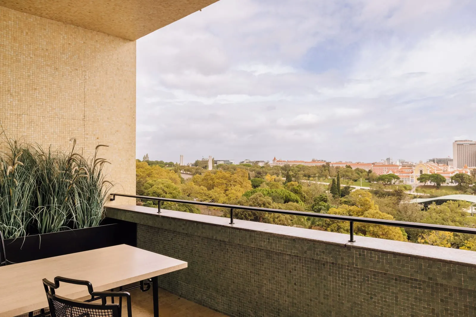 Deluxe Park-View Room terrace at Four Seasons Ritz Lisbon: a table and chair looking over the treetops of the park
