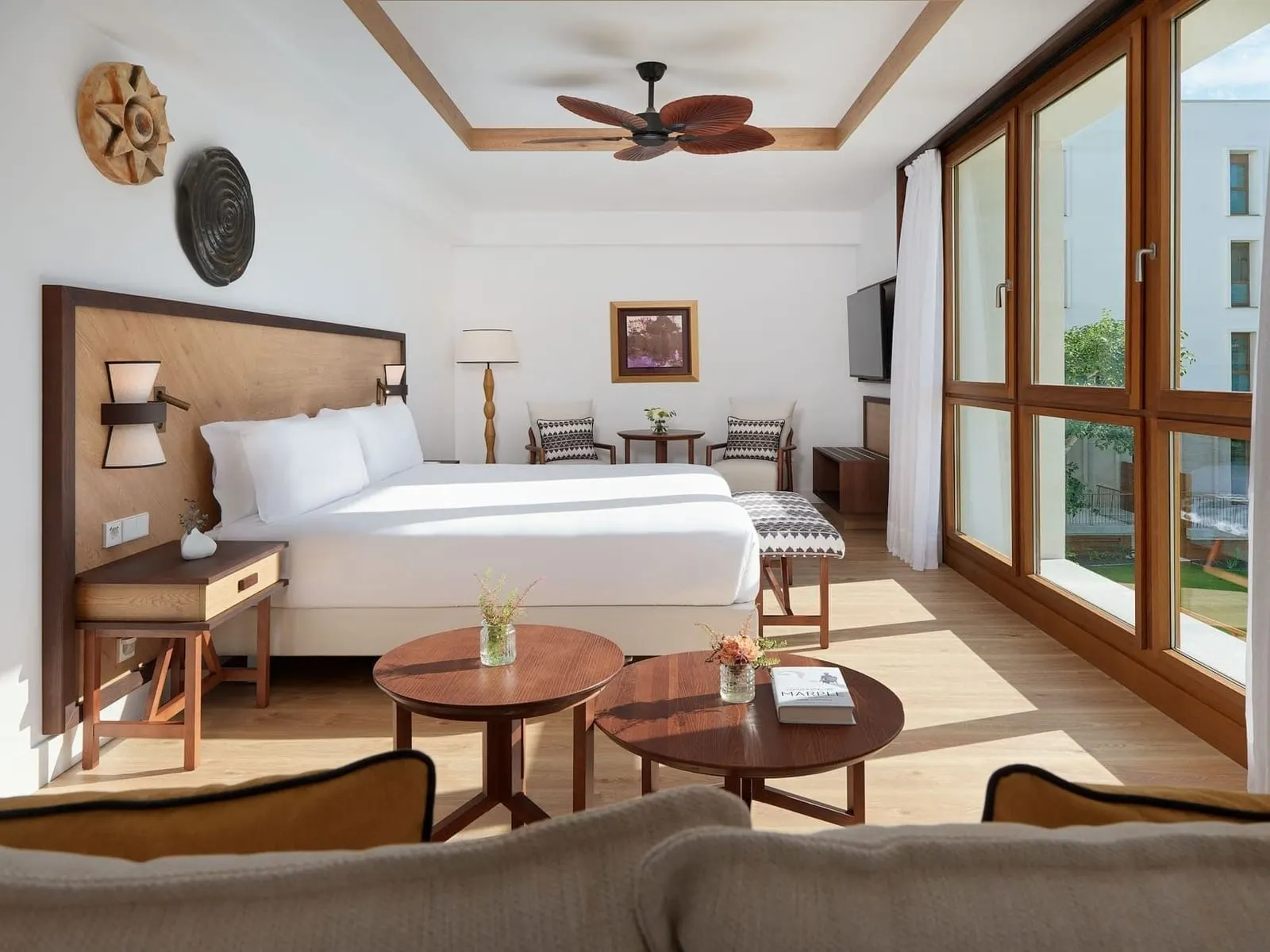 Junior Suite Garden View at Gran Hotel Taoro: the bed, two round tables and a wall of tall windows