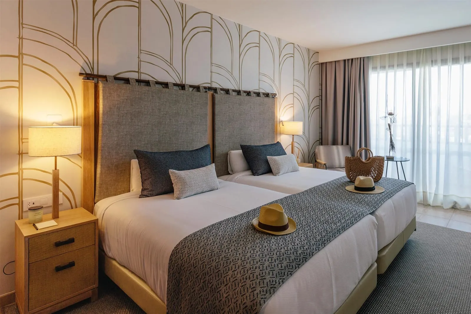 Preferred Club Double Ocean View al Secrets Lanzarote Resort & Spa: letti singoli uniti con un runner grigio, lampade da comodino e una finestra da cui entra la luce