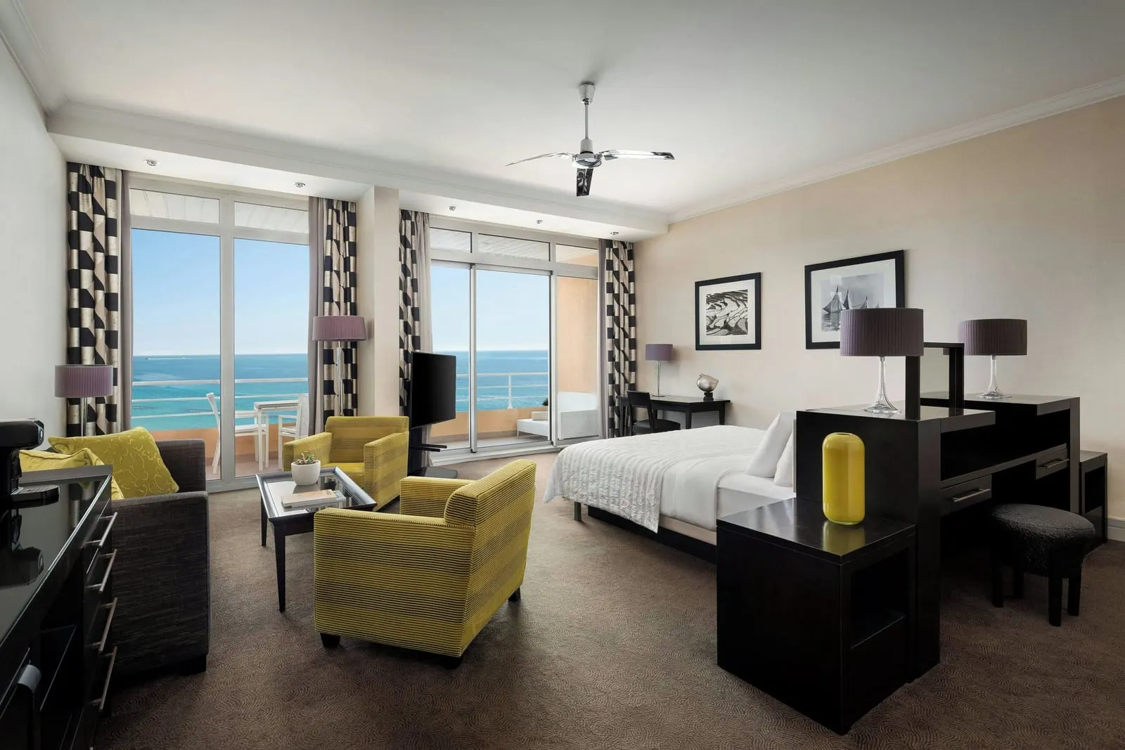 Junior Suite at Le Méridien Beach Plaza: a sitting area, the bed and glass doors to a balcony over the sea
