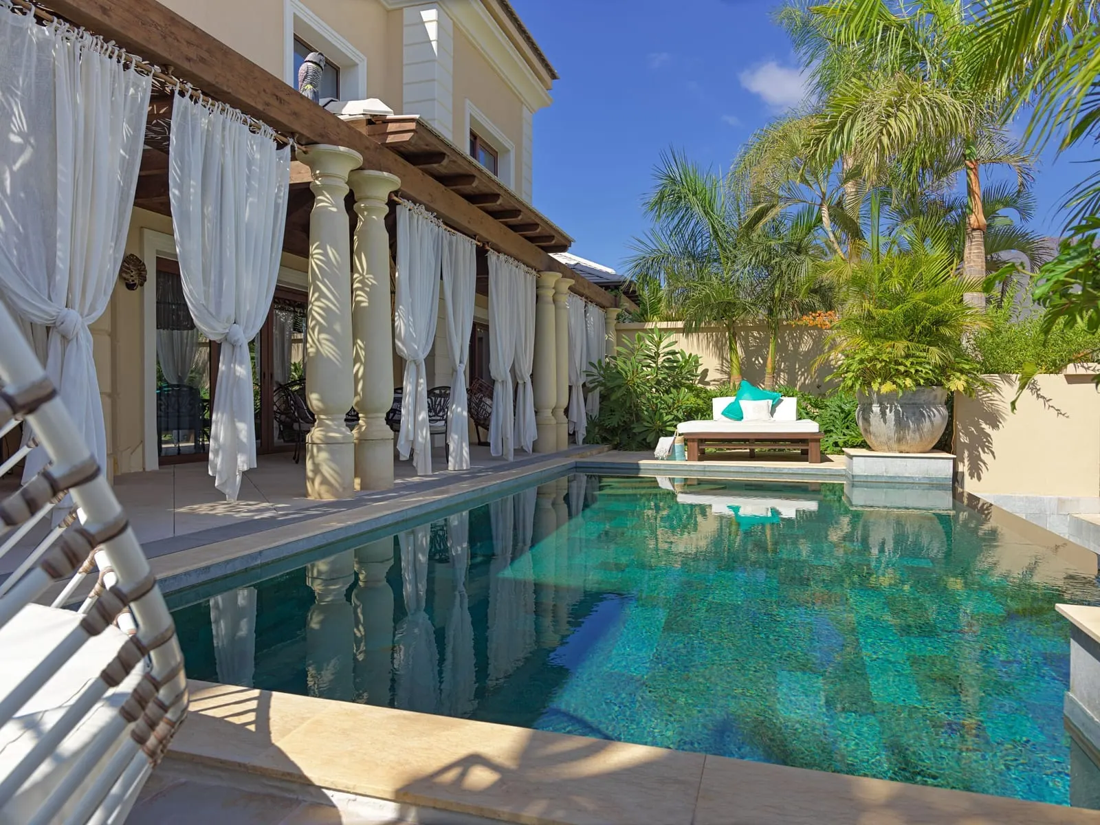 Paradise Villa at Royal River: the pool beside a colonnade hung with white curtains