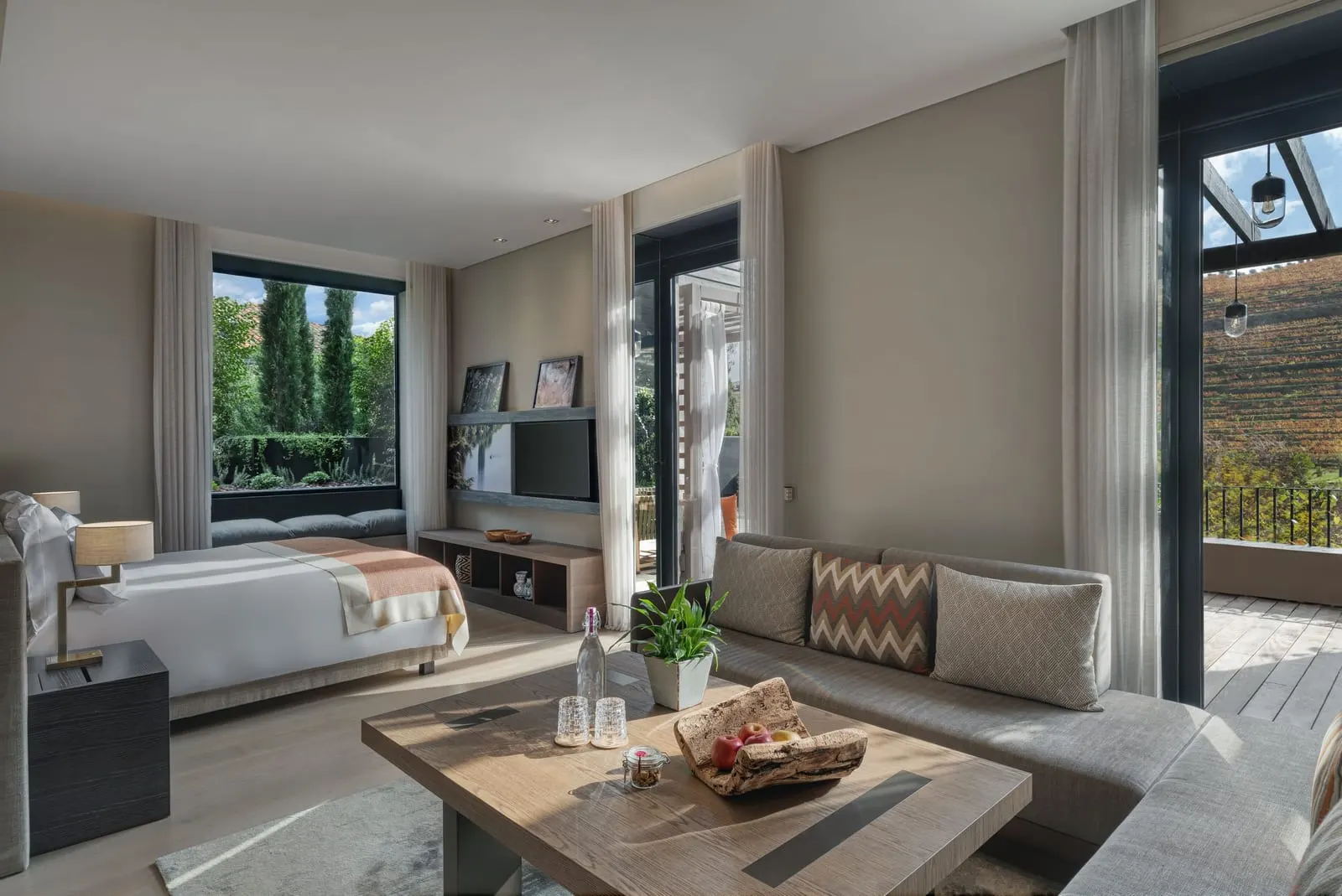 Vineyard Junior Suite with Terrace at Six Senses Douro Valley: the bed, a sofa and glass doors to the terrace