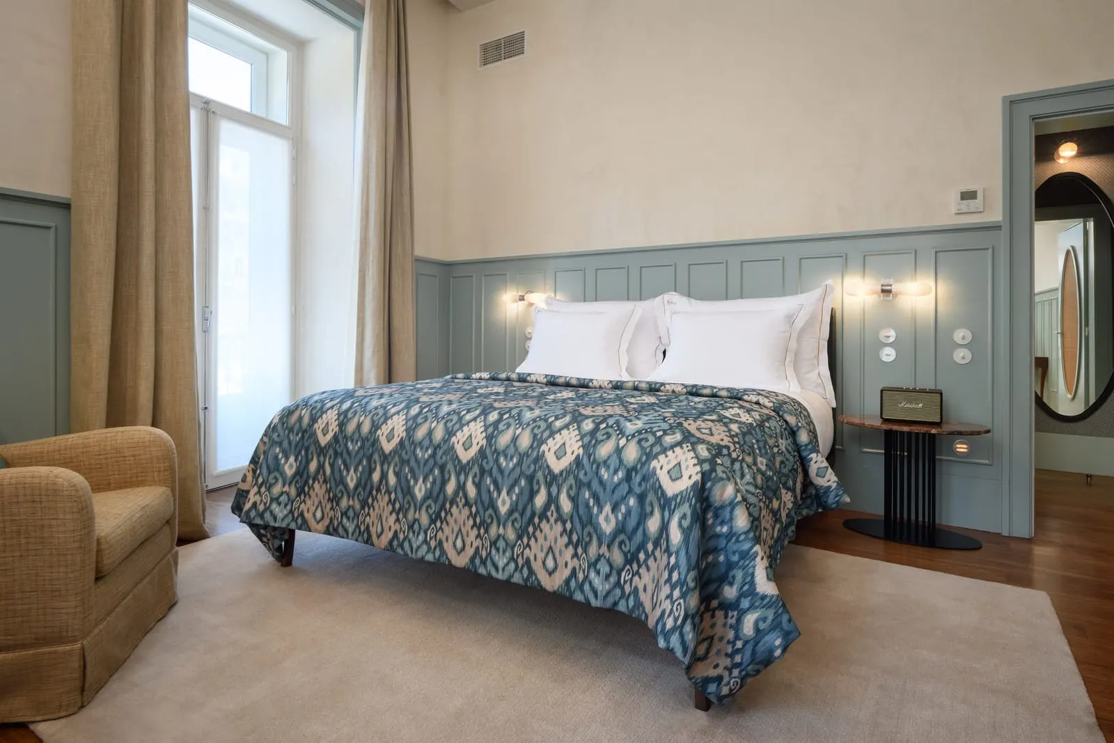 Classic Chiado Corner at Bairro Alto Hotel: a double bed with a blue throw, an armchair and a tall window