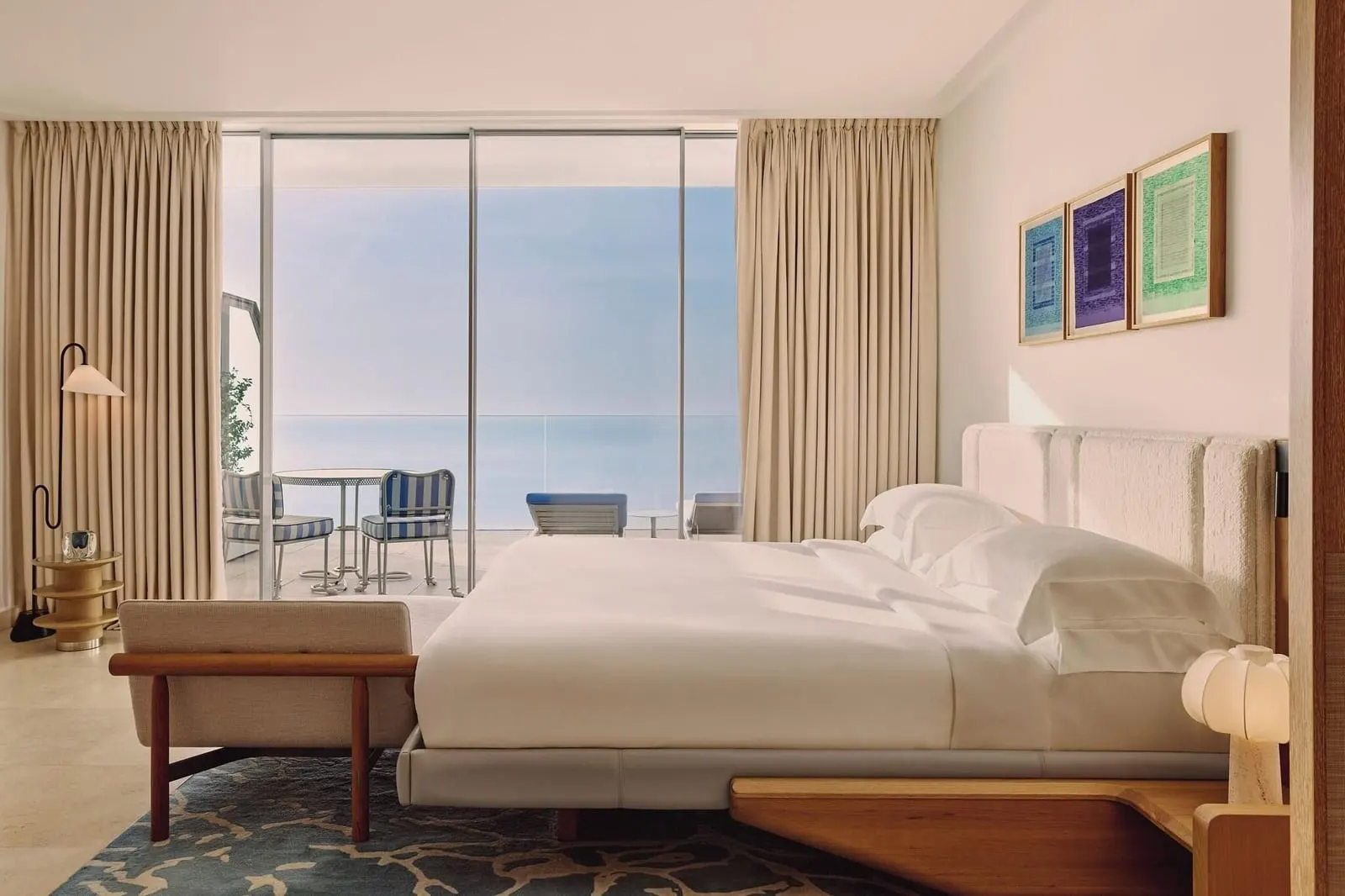 Grand Sea View Studio at The Maybourne Riviera: the bed with a bench at its foot and glass doors to the terrace and the sea