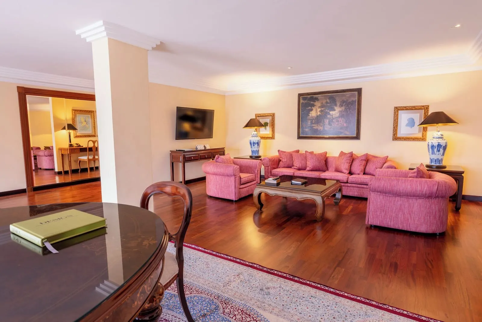 Penthouse Suite at Hotel Botánico: the living room, with pink sofas, a round table and paintings