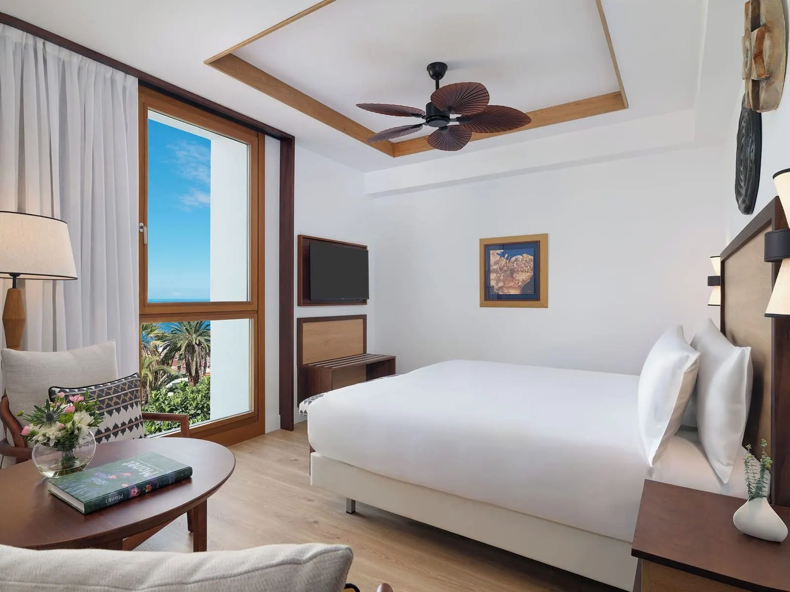 Double Deluxe Room Ocean View at Gran Hotel Taoro: the bed, a round table and a window onto palms and the sea