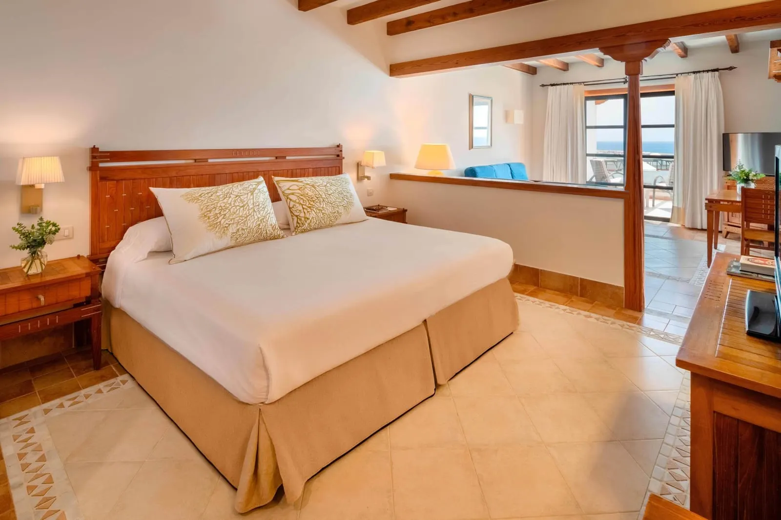 Junior Suite Sea View at Princesa Yaiza Suite Hotel Resort: a king bed with the sitting area a step up behind it, in one open room