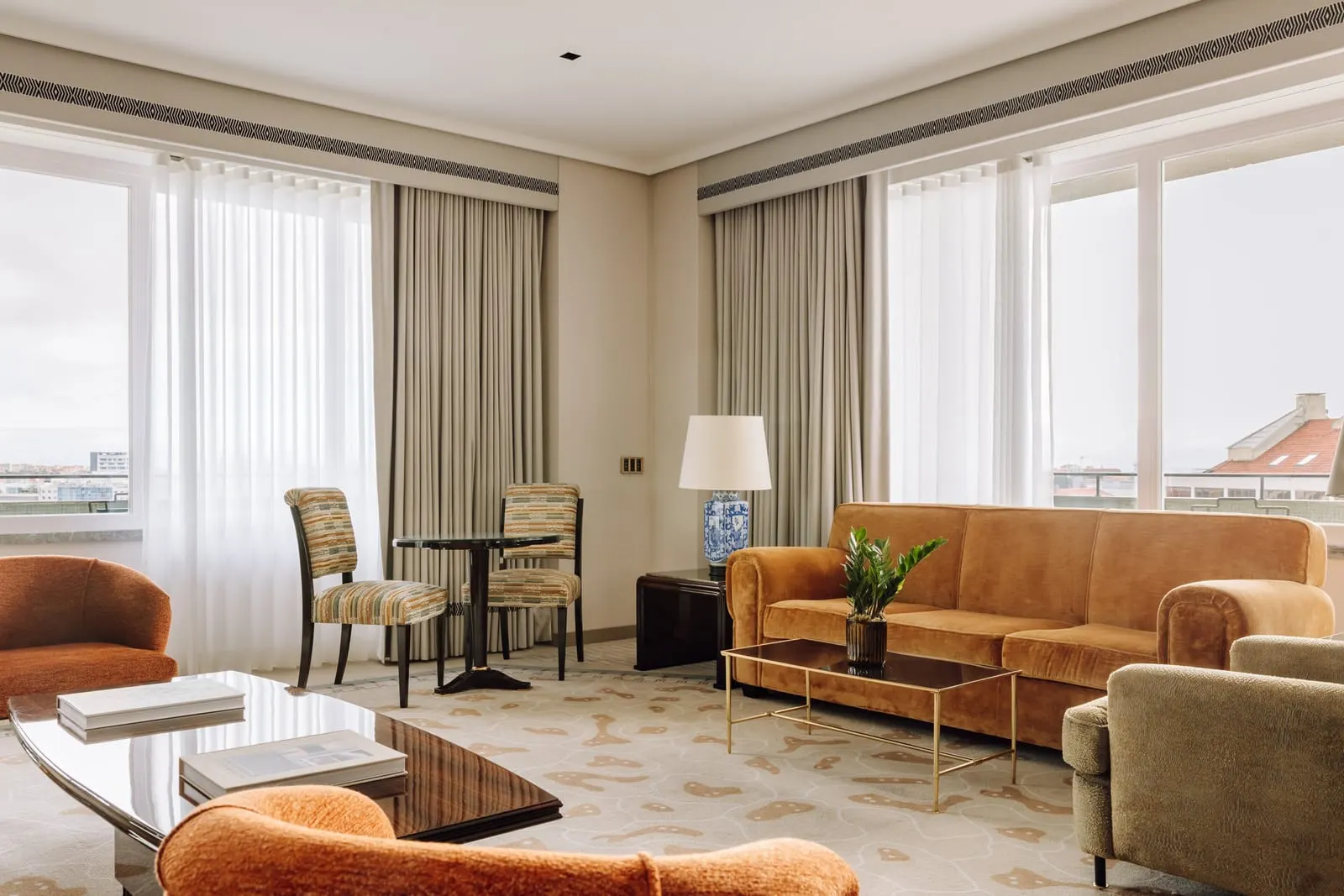 Grand One-Bedroom Suite at Four Seasons Ritz Lisbon: the living room, with an orange sofa, armchairs and a table for two
