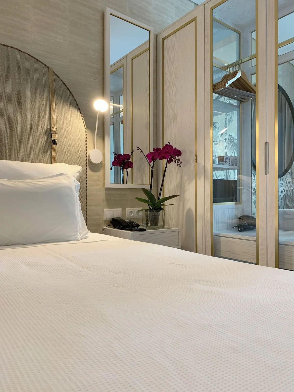 VidaMar Resort Hotel Madeira Vida Junior Suite Garden View：アーチ形のヘッドボードのベッド、読書灯、ガラス扉のワードローブ