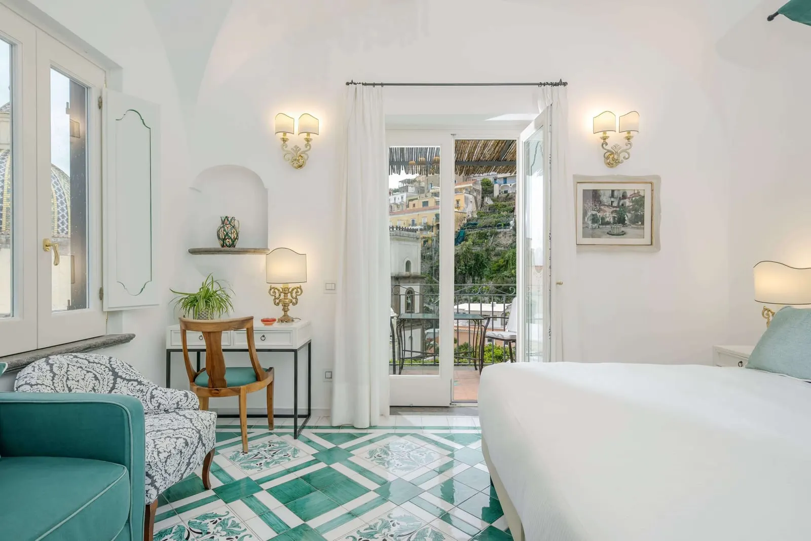 Special Superior side sea view terrace im Palazzo Murat: ein weißes Bett, ein türkisgrünes Sofa und ein Schreibtisch, mit geöffneten Glastüren zu einer Terrasse
