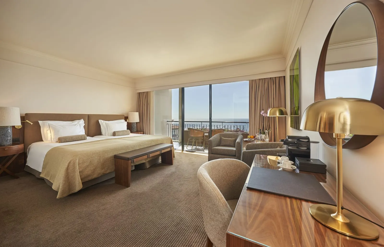 Superior Upper Floors Sea View at The Cliff Bay, by PortoBay: twin beds made up as one, a Nespresso machine on a walnut desk, armchairs, fruit on the table and a balcony over the open sea