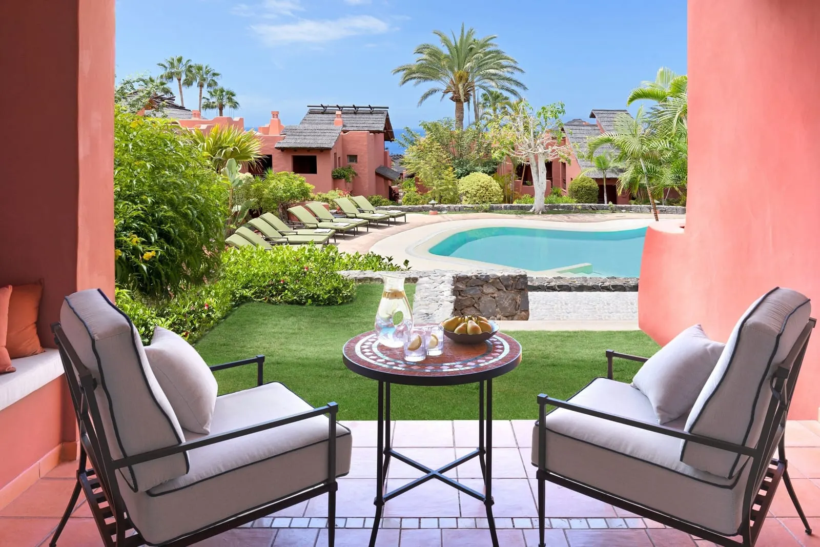 Retreat One Bedroom Suite, Adults Only, Garden View at the Ritz-Carlton Abama: two terrace chairs facing a lawn and a pool