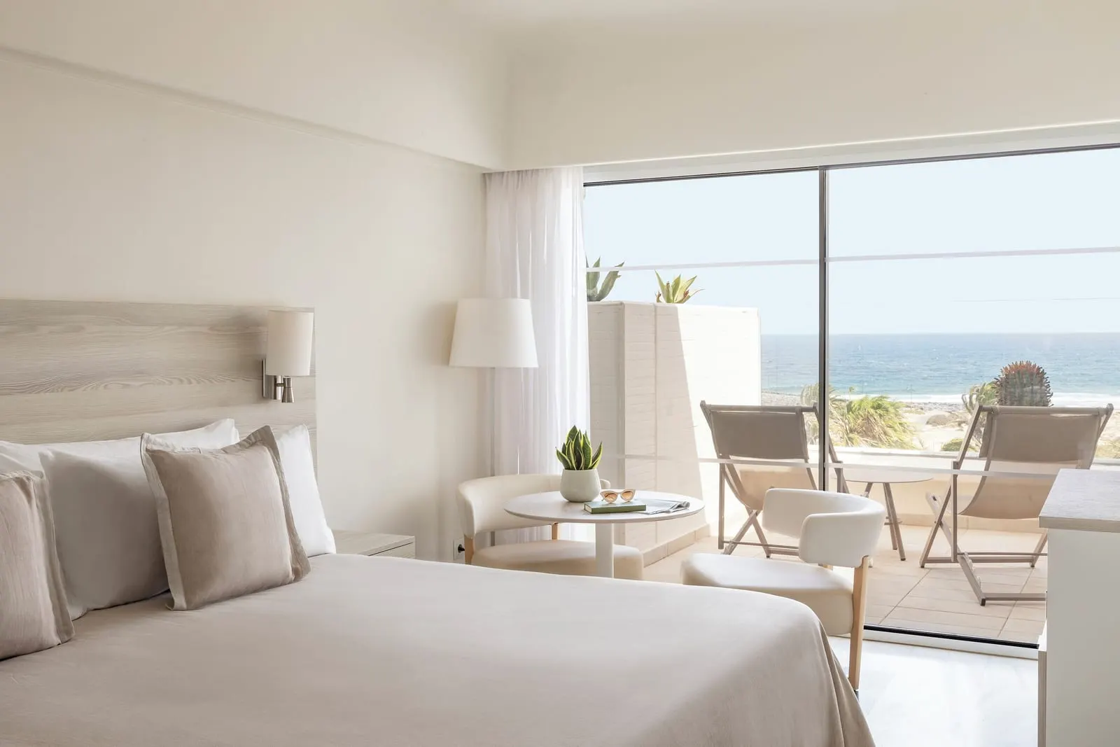 Premium Ocean Front at Paradisus Salinas Lanzarote: a bed beside a wide sliding window opening onto a terrace with the sea beyond