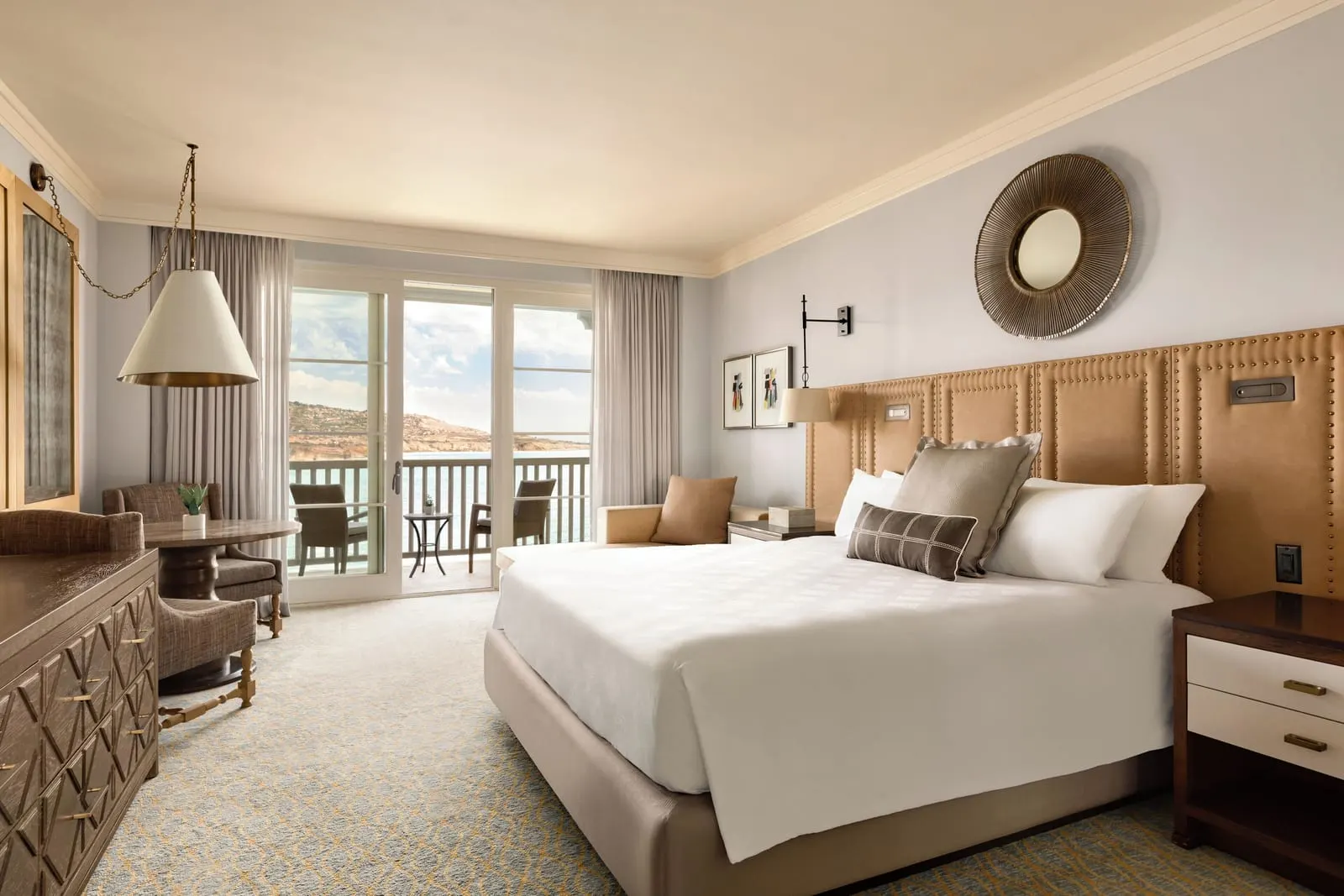 Hotel King Guestroom, Premier Ocean View at Terranea Resort: a king bed with a tan quilted headboard, a seating area and glass doors onto a balcony