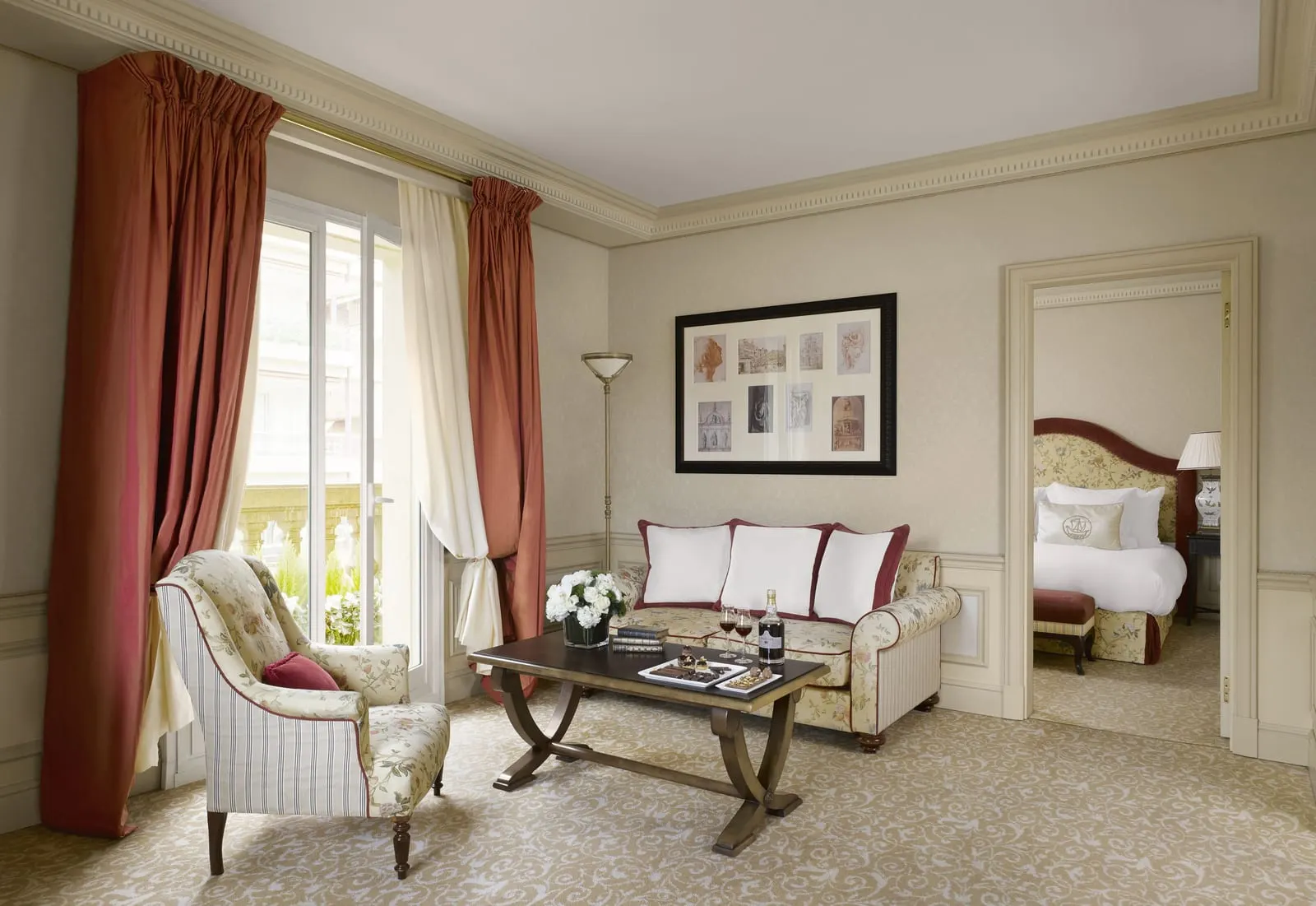 Deluxe Suite at Hôtel Métropole Monte-Carlo: the lounge with a sofa and an armchair, the bedroom through a door