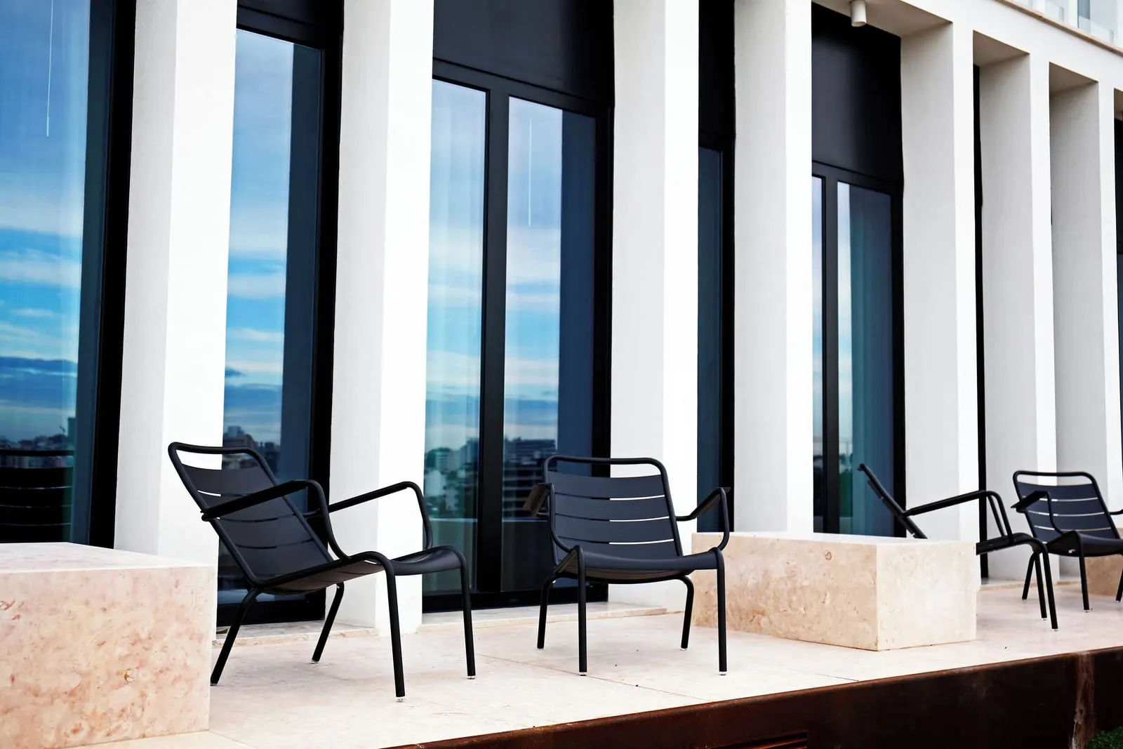 Superior Terrace City View Room terraces at Memmo Príncipe Real: lounge chairs outside glass doors, between low stone blocks