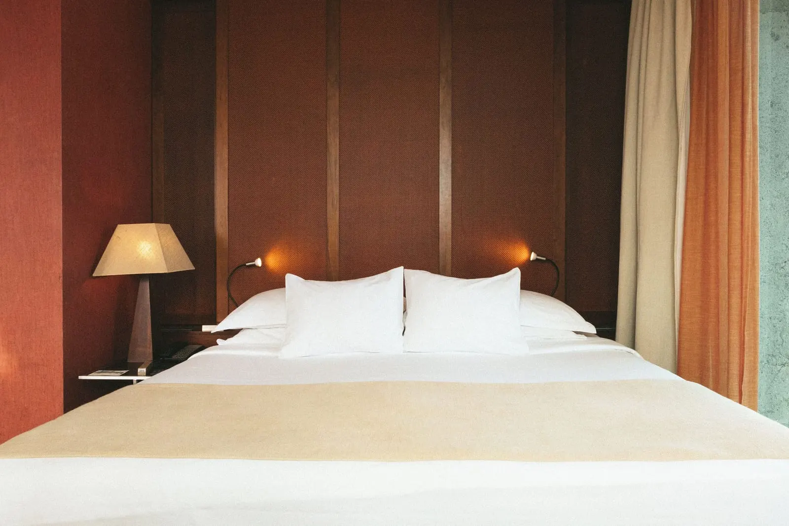 Deluxe Suite Golf View at Salobre Hotel Resort & Serenity: the bed, made up in white, against a wood-panelled wall with two reading lights and a bedside lamp