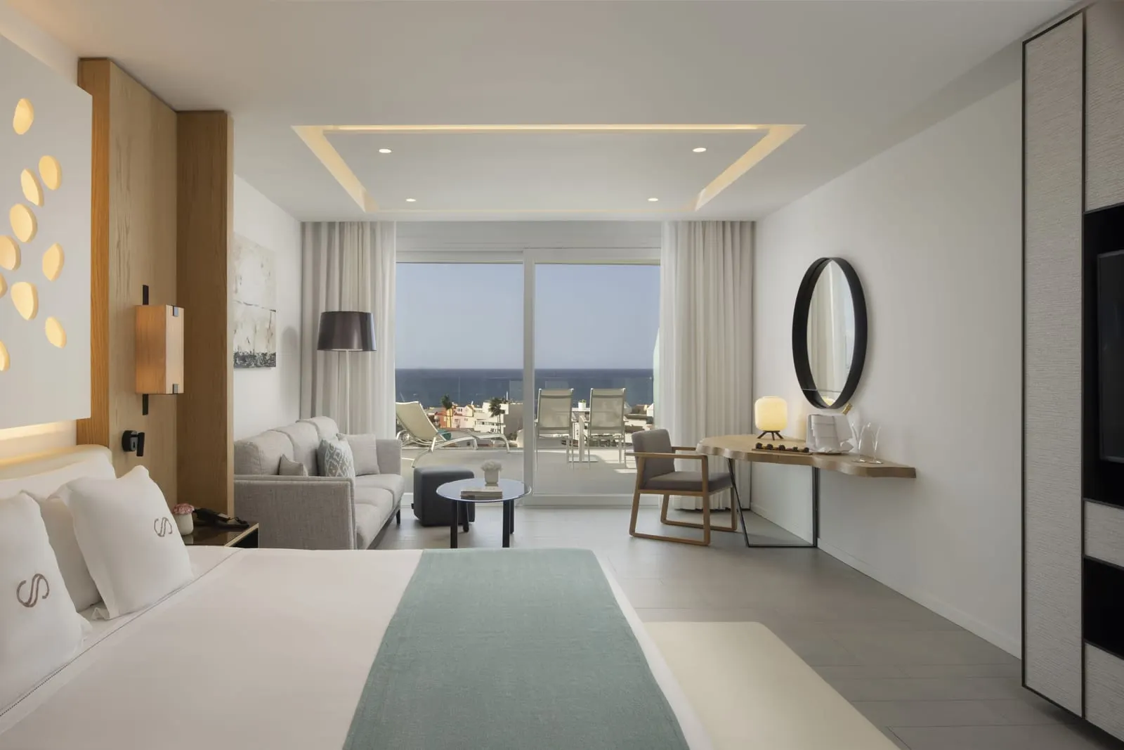 Junior Suite Sea Front View at Royal Hideaway Corales Beach: the bed, a sofa, a desk and glass doors to the sea