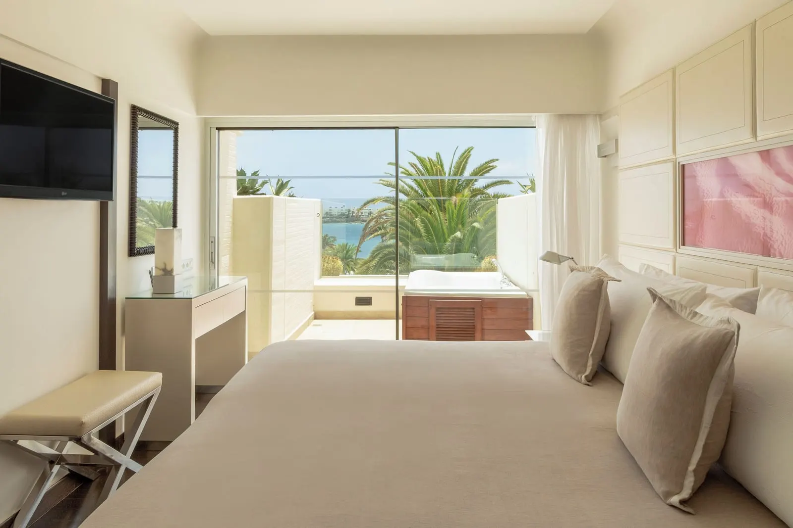 The Reserve Suite Ocean Front with Whirlpool at Paradisus Salinas Lanzarote: a bed facing a window and terrace with palm trees and the sea