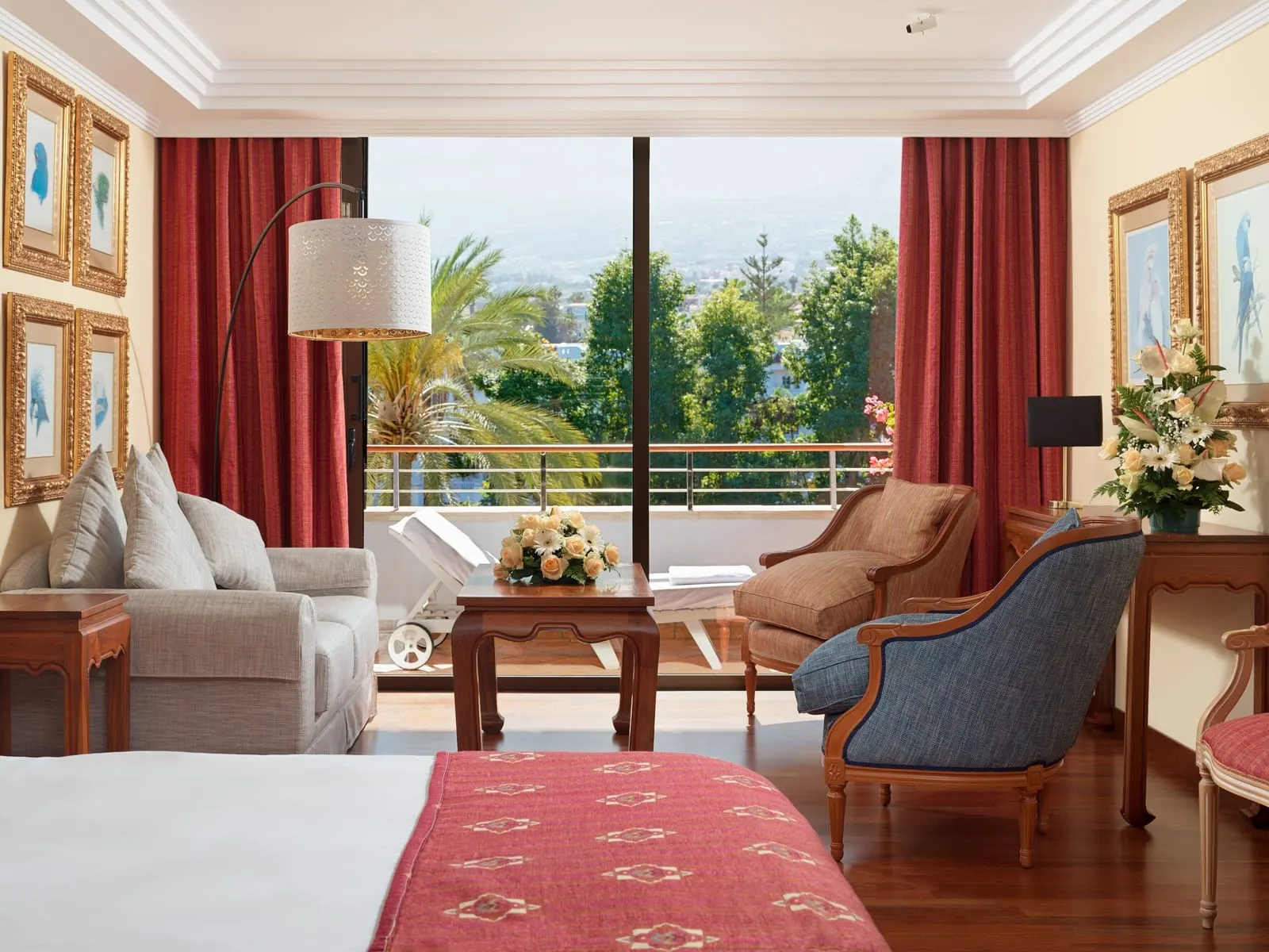Superior Deluxe Teide View at Hotel Botánico: armchairs and a sofa by a window onto palms, the town and hazy hills