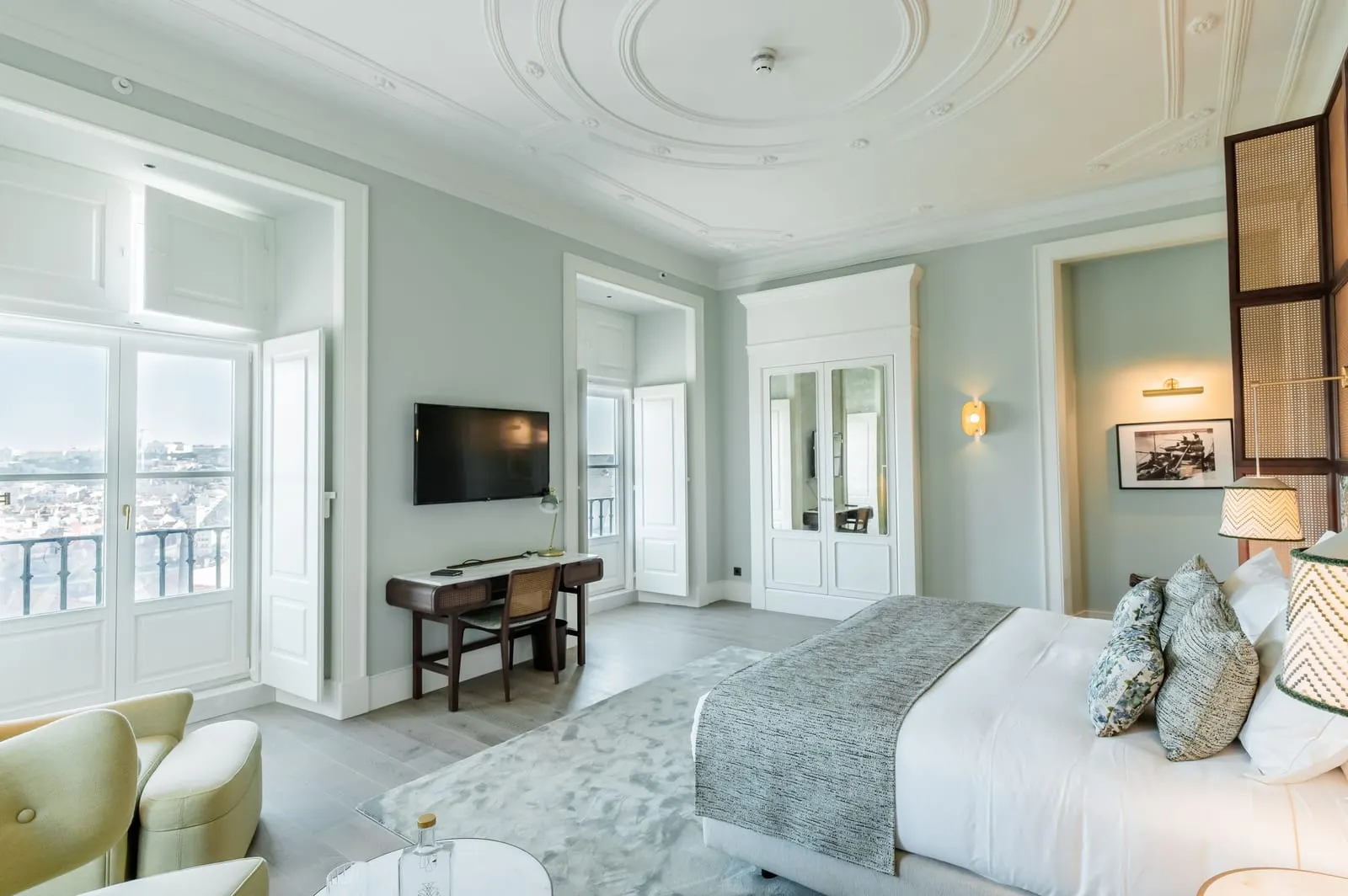 Deluxe Room at Palácio Ludovice: a stucco ceiling, French windows with a railing over the city, a desk and the bed