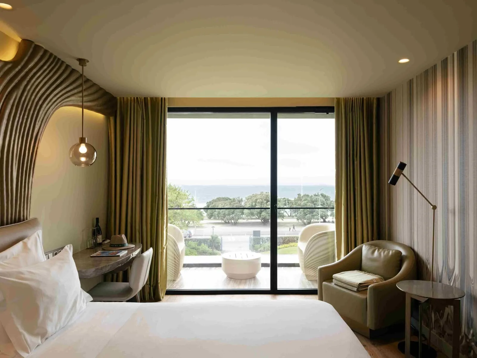 Onice Sea View Room at Vila Foz: the bed, a desk, an armchair and glass doors to a balcony facing the sea