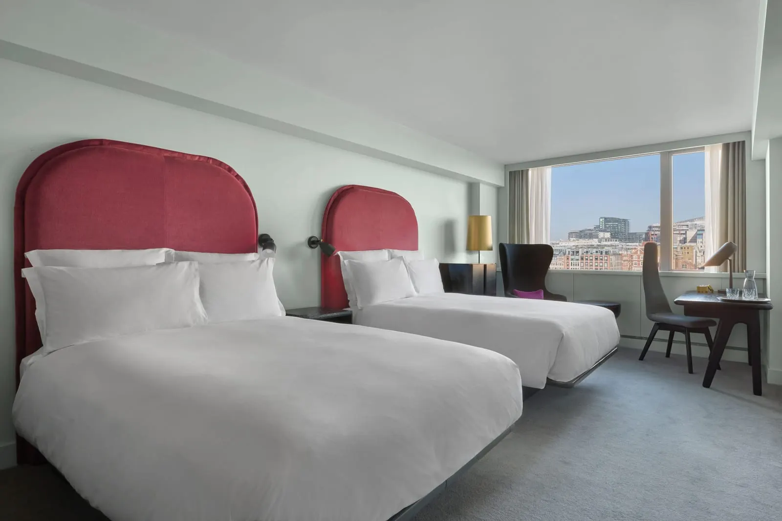 Riverview Deluxe Double Double at Sea Containers London: two double beds with red headboards, a desk and a window
