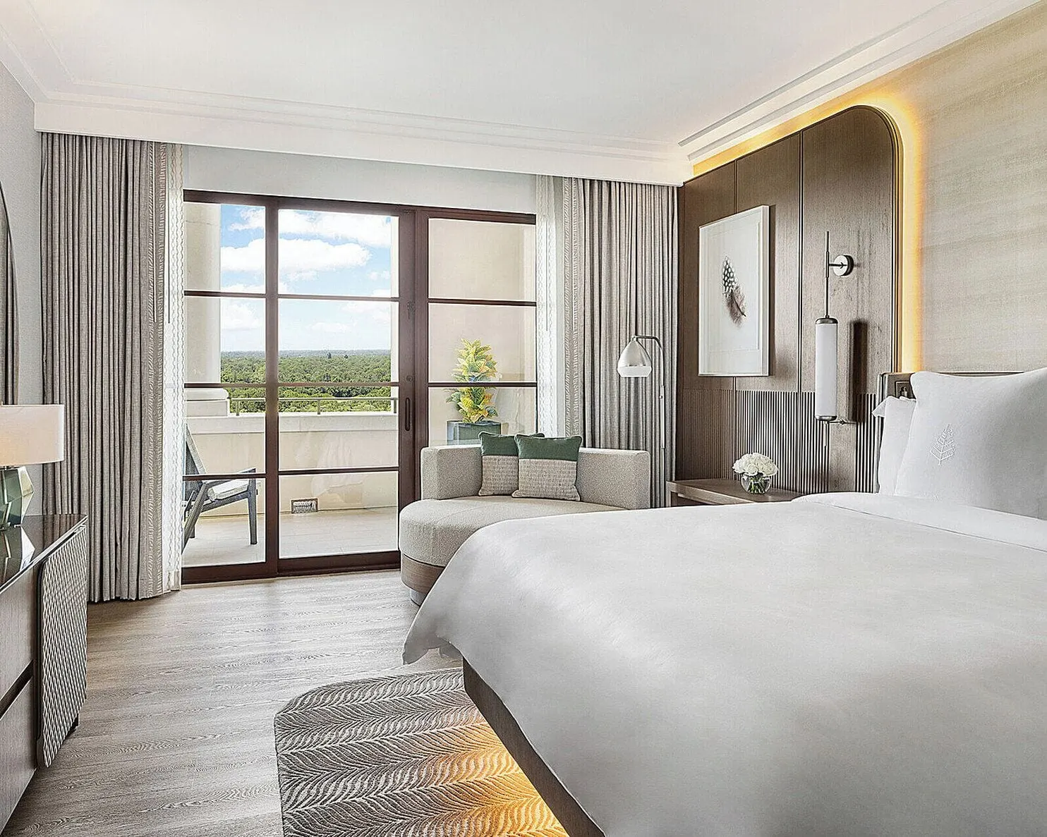 Park View Deluxe Suite im Four Seasons Resort Orlando at Walt Disney World Resort: das Schlafzimmer, mit einem Kingsize-Bett vor einer beleuchteten holzvertäfelten Wand, einer geschwungenen Chaiselongue und Glastüren zur Terrasse