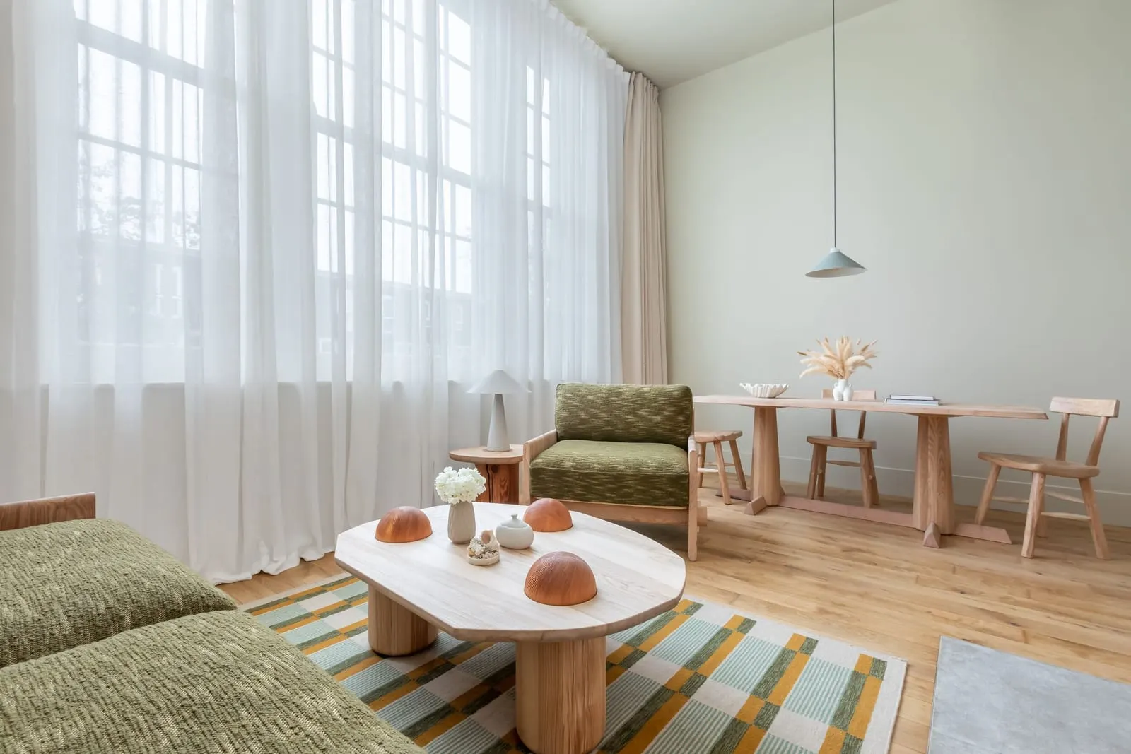 Signature One Bedroom Suite at Town Hall Hotel: a coffee table, a green armchair and a dining table by tall curtained windows