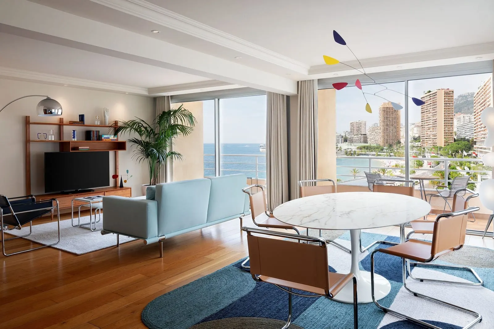 Apartment 915 at Le Méridien Beach Plaza: the living and dining room with a round table and glass doors to a balcony and the sea