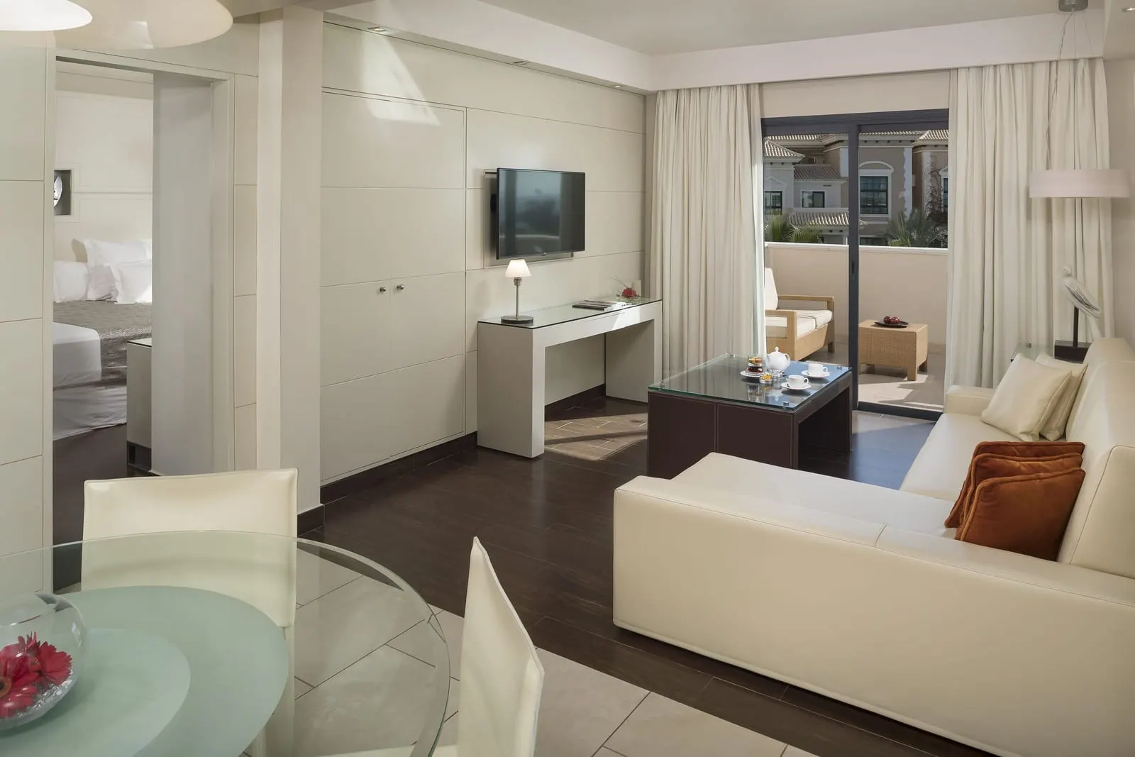RedLevel Suite Resort View at Gran Meliá Palacio de Isora: the living room, a white sofa, a desk and the balcony door