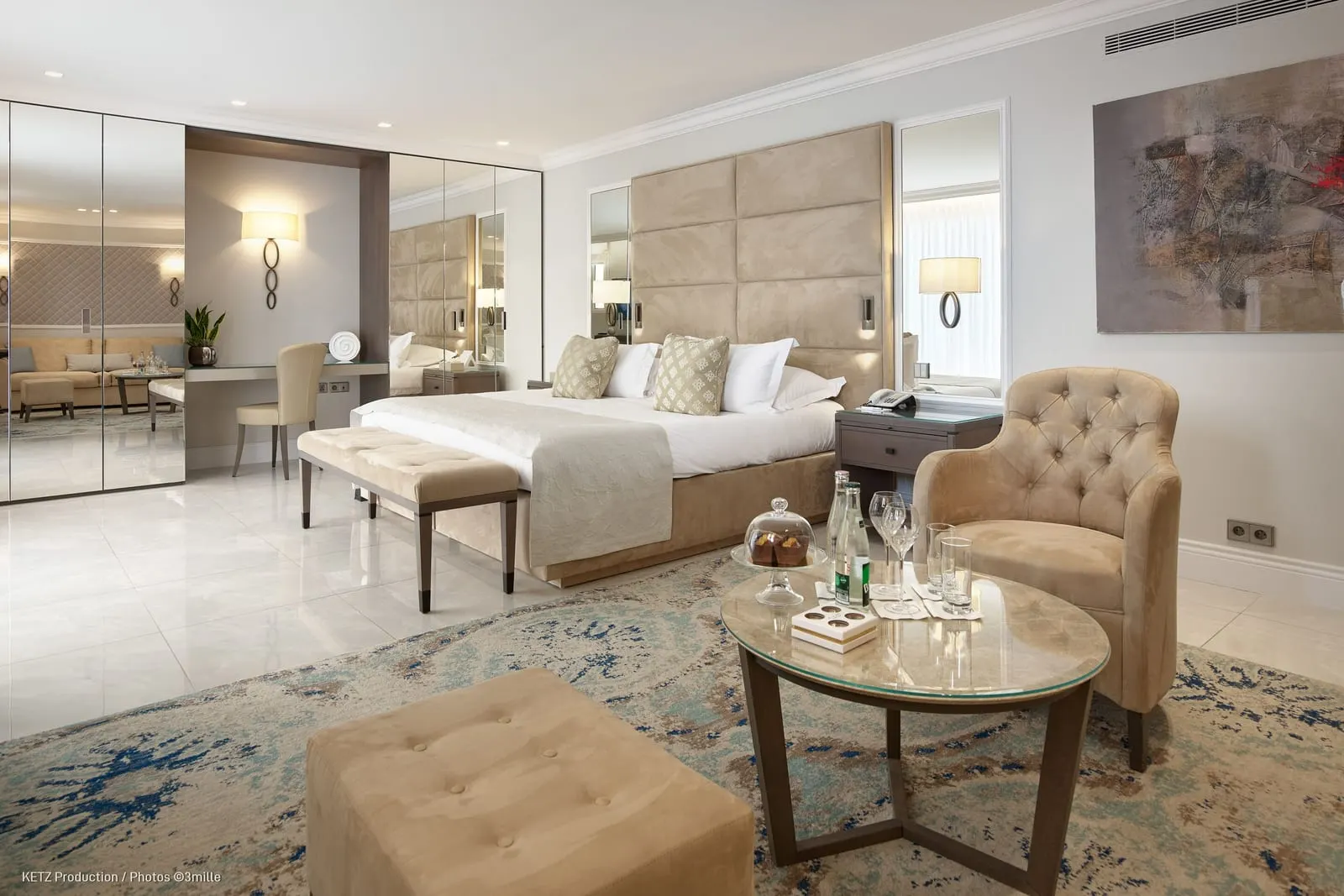 Suite 910 or 920 in Les Jardins at Cap Estel: the bedroom with a bench, an armchair and a round table
