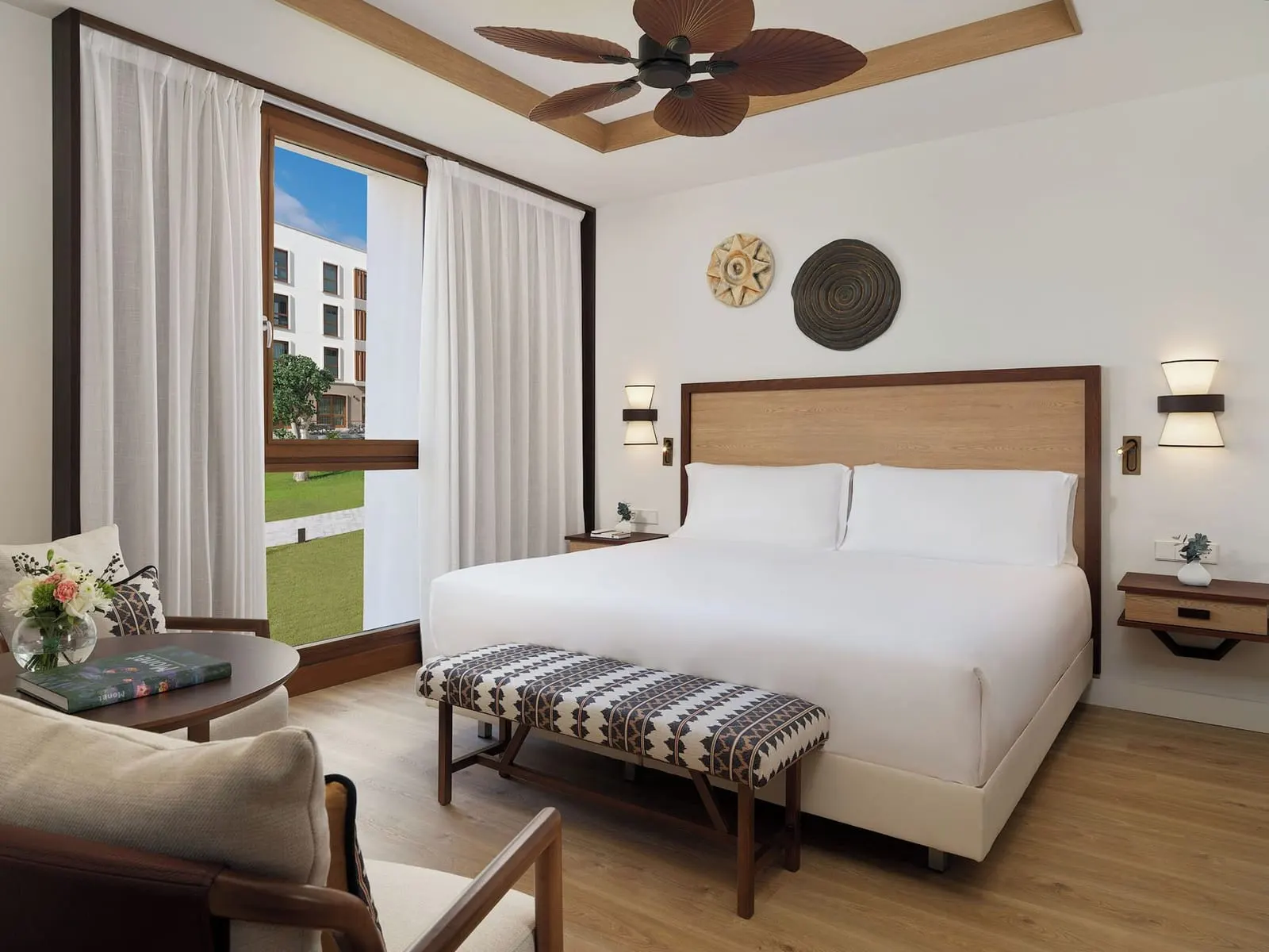 Double Deluxe Room Garden View at Gran Hotel Taoro: the bed, a bench and a window onto the lawn and a hotel wing