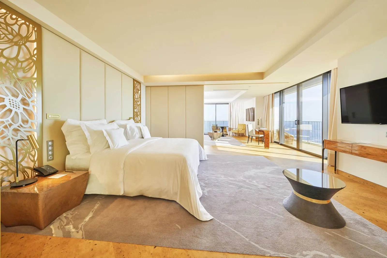 Superior Ocean Suite im Savoy Palace: ein Kingsize-Bett in einem langen, offenen Raum, der zu einem Sitzbereich und Glastüren zur Terrasse führt