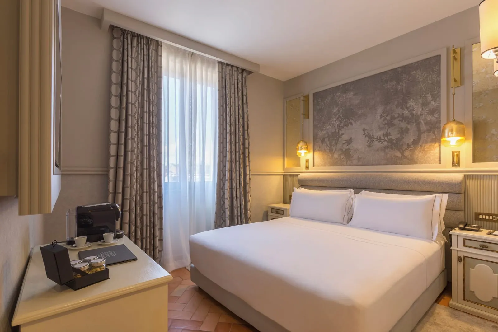 Chiostro Prestige at Donna Camilla Savelli: a double bed under a grey painted panel, a coffee machine on a side table
