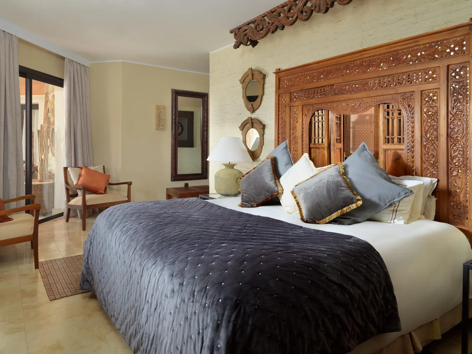 Imperial Villa at Royal Garden Villas: a bed with a dark quilt against a carved wooden headboard